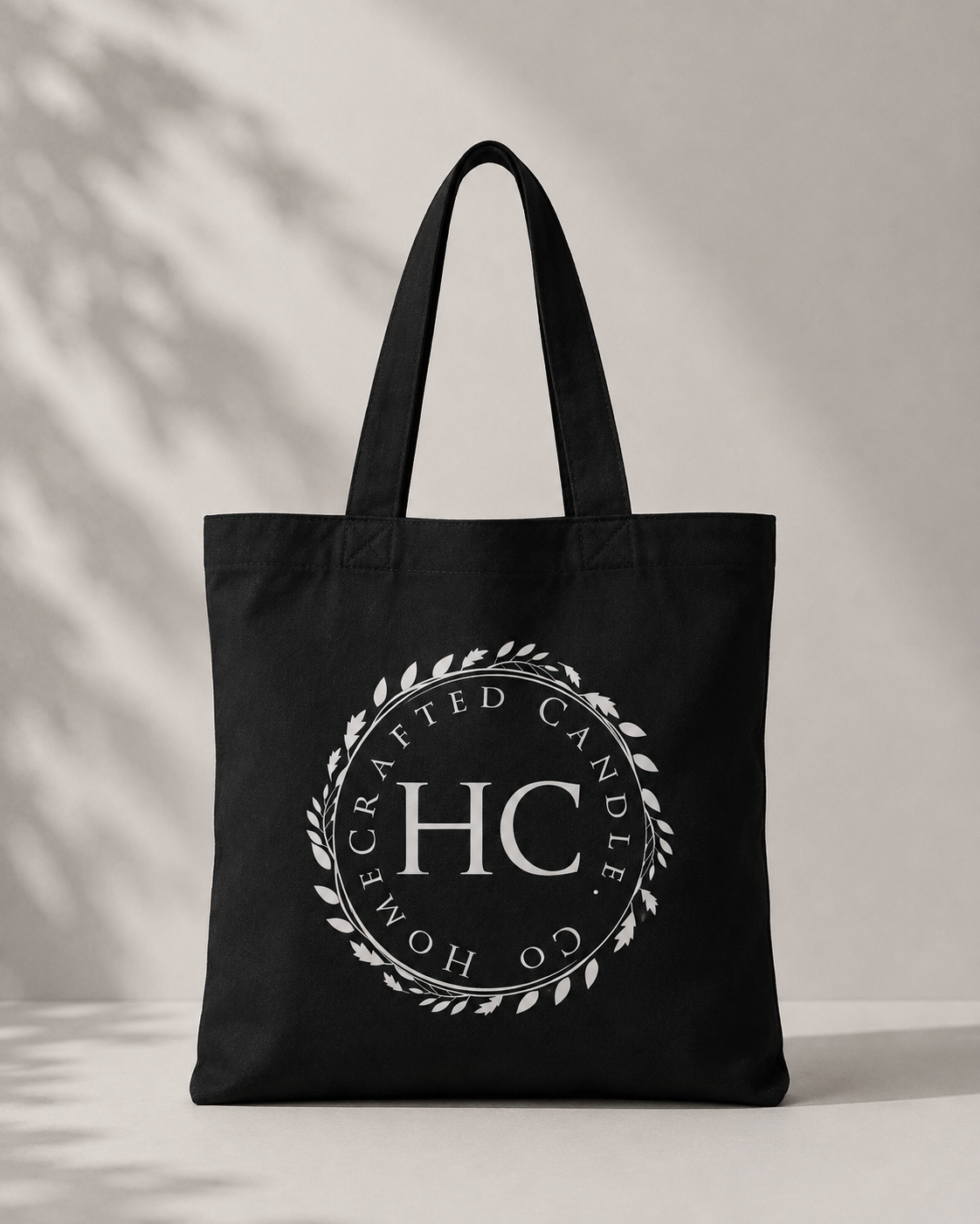 black canvas tote bag with centered white emblem print