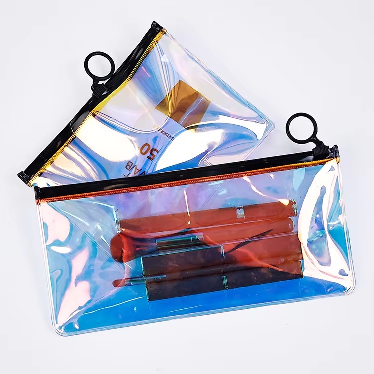 blue holographic PVC makeup pouch with black ring pull and brushes