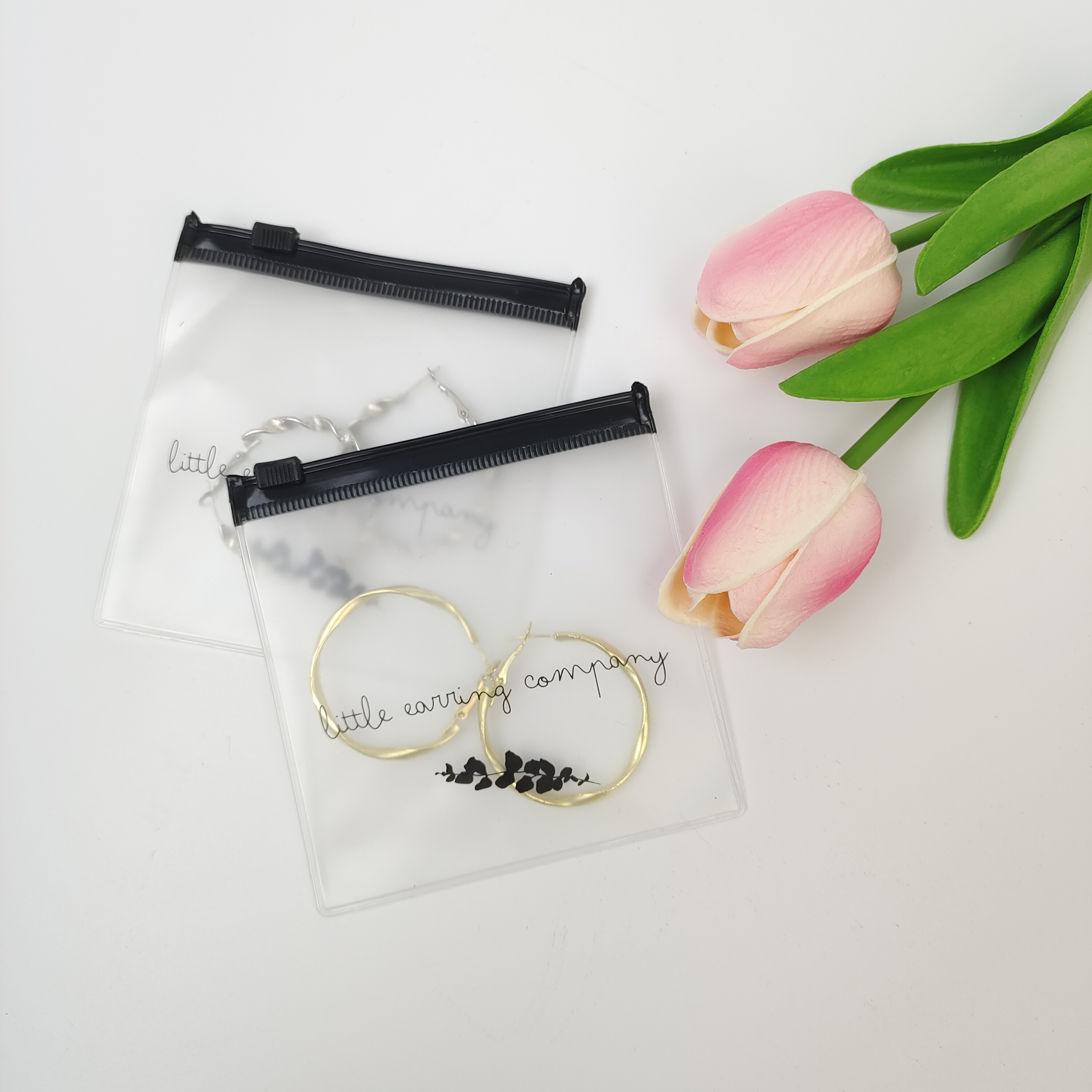 small clear PVC zipper pouch displaying earrings - view 2