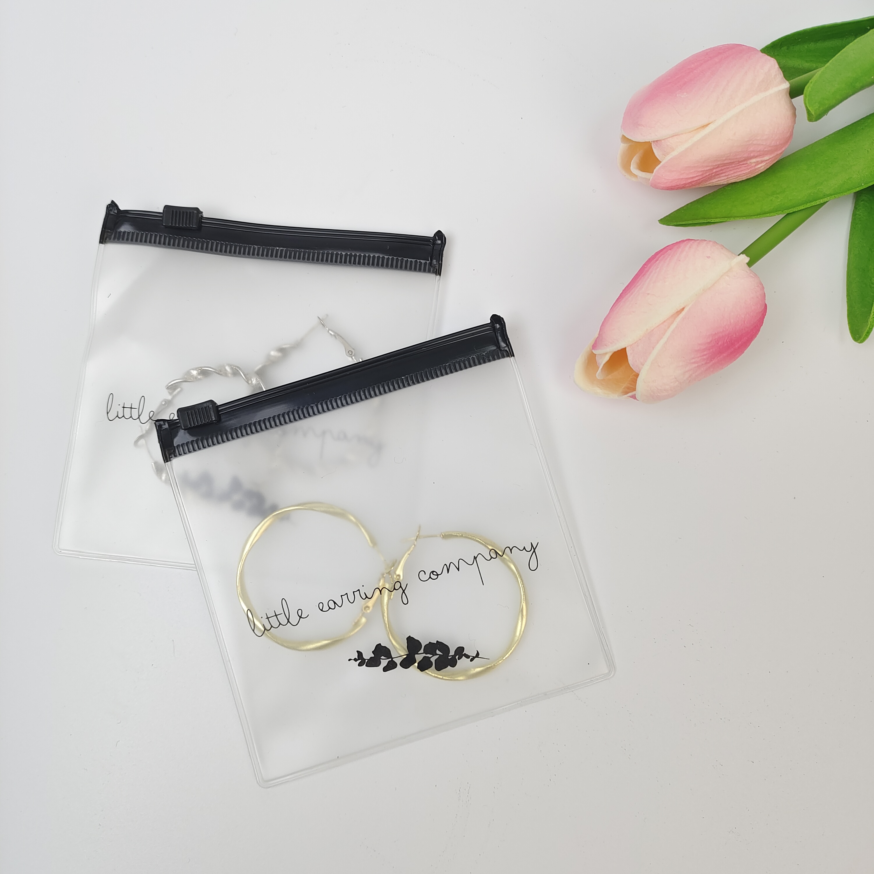 small clear PVC zipper pouch displaying earrings - view 3