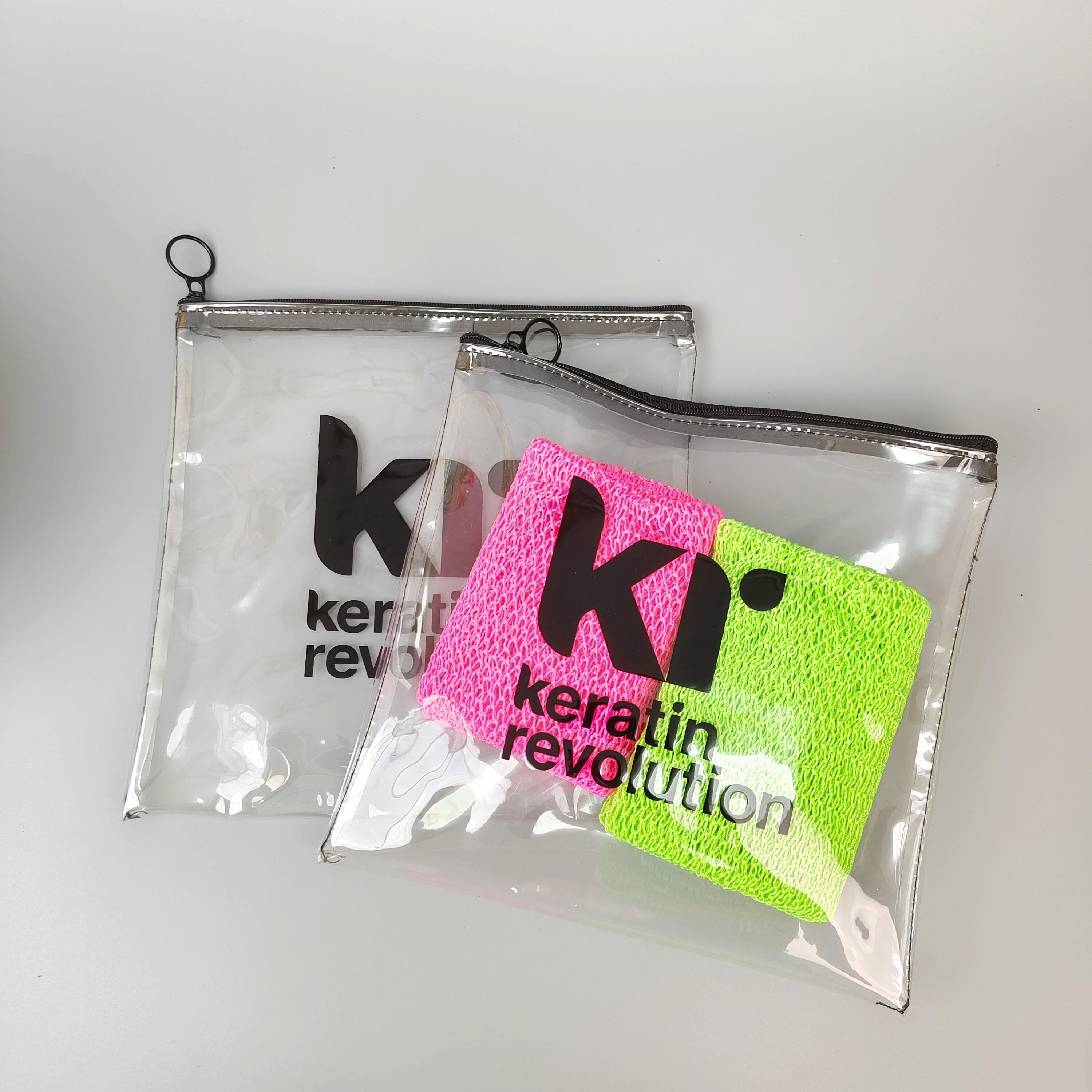 clear printed PVC zipper pouch holding colorful hair care accessories - view 1