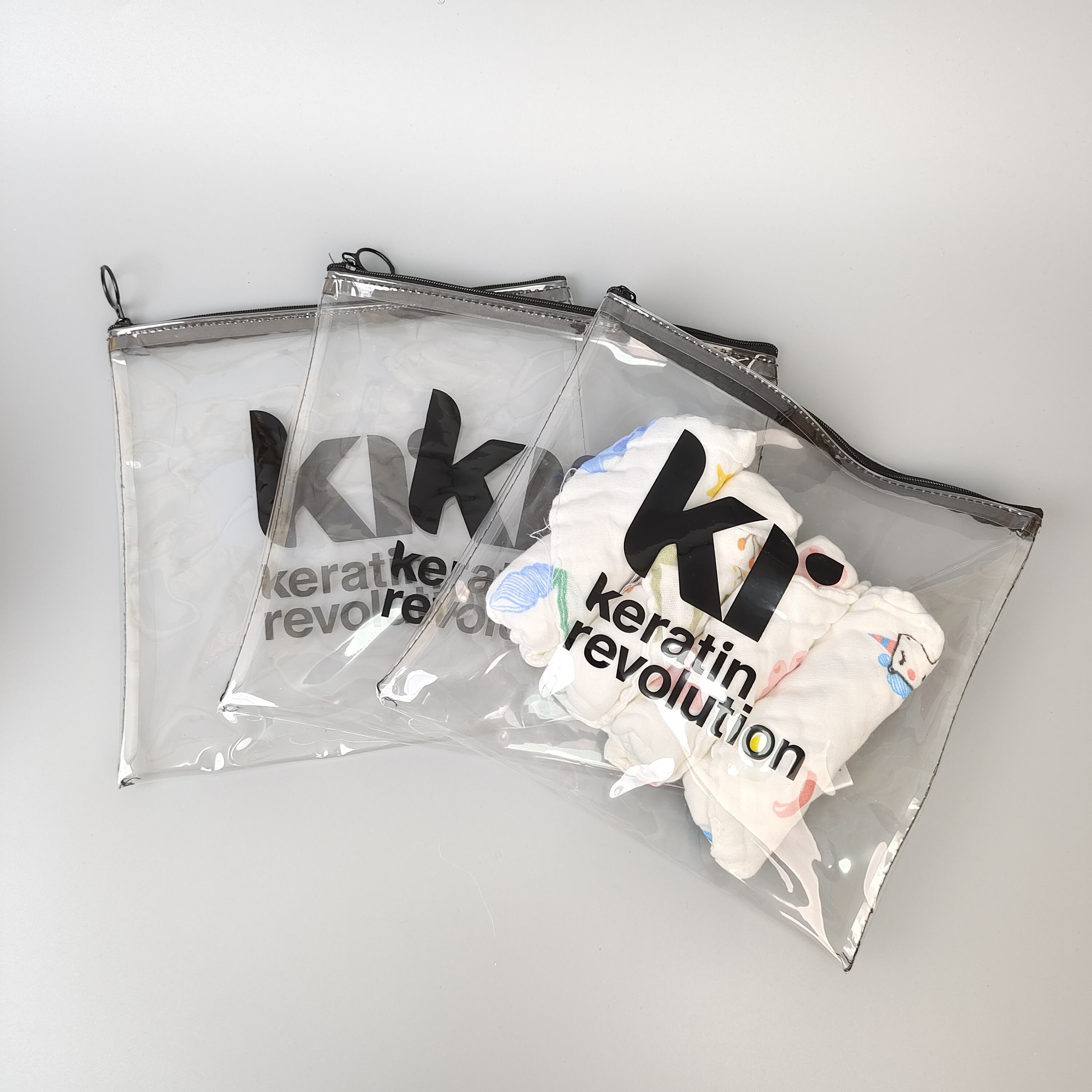 clear printed PVC zipper pouch holding colorful hair care accessories - view 4