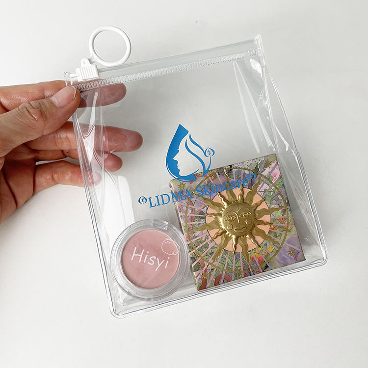 clear PVC skincare pouch with white circular ring pull and blue logo