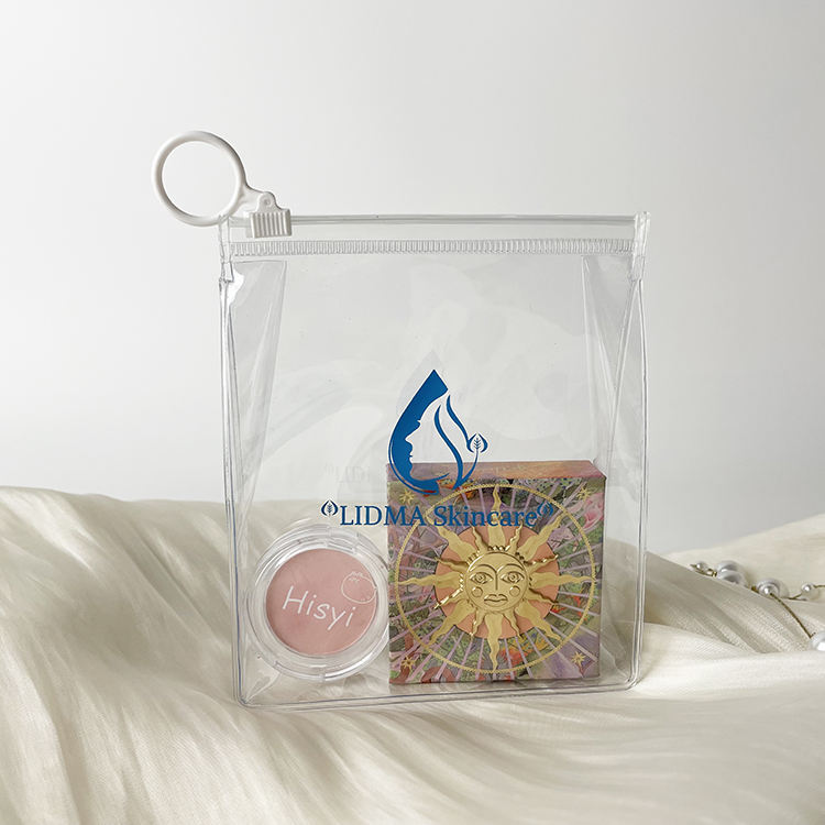 clear PVC skincare pouch with white circular ring pull and blue logo - view 2