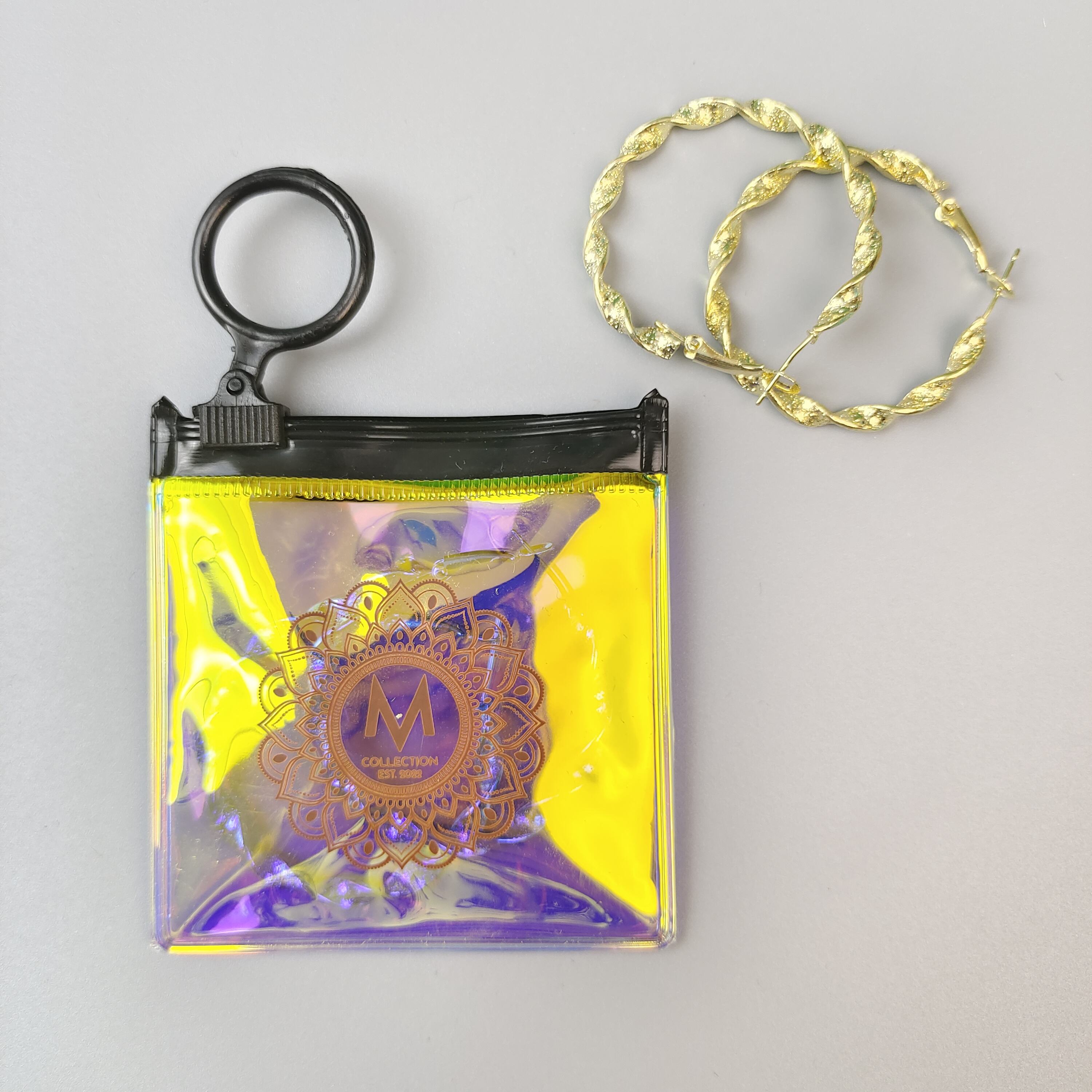 small holographic PVC jewelry pouch with circular black ring pull