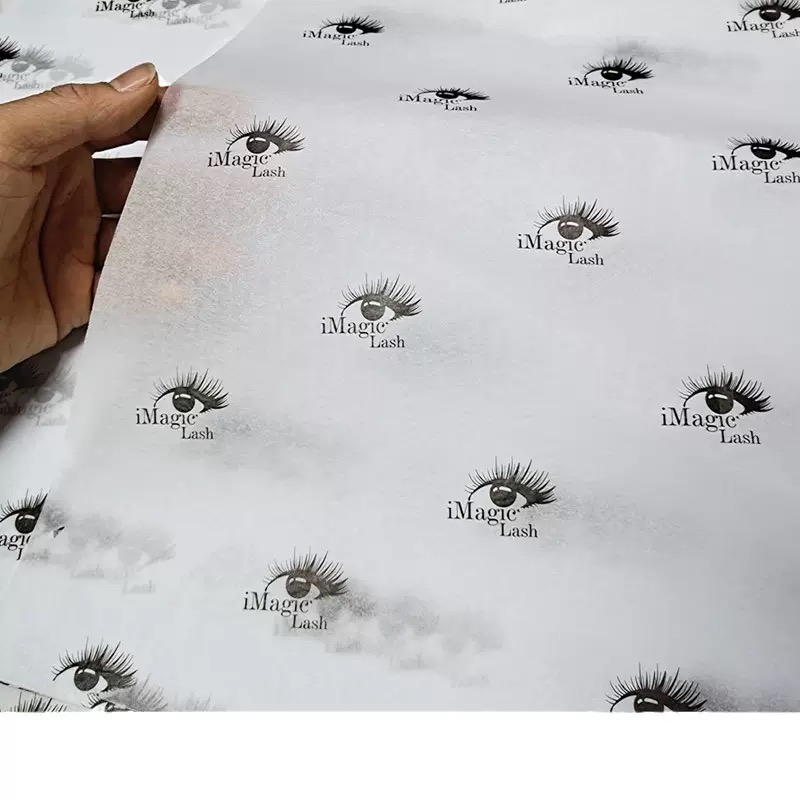 white tissue paper with repeating black eyelash logo pattern