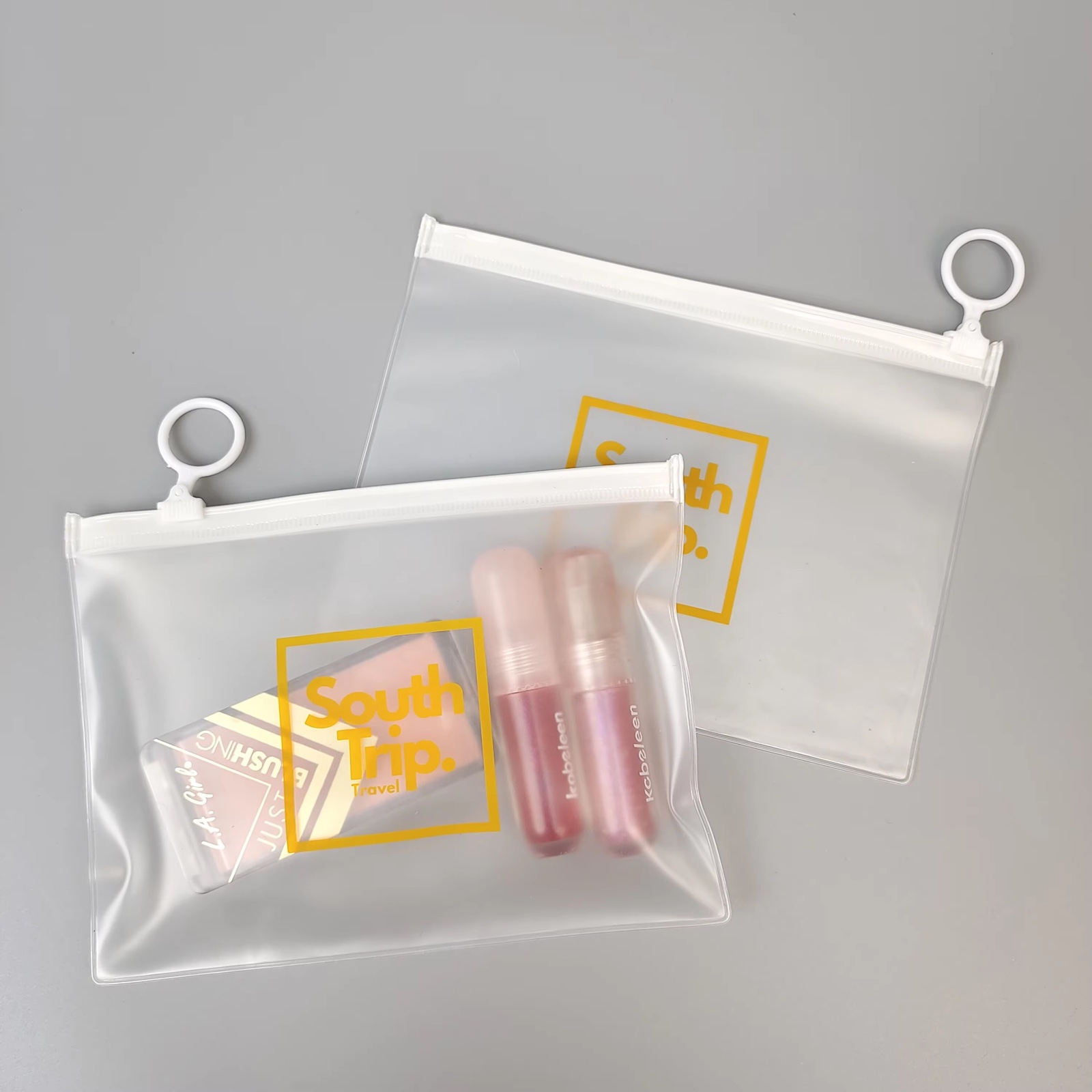 frosted PVC travel pouch with white zipper and circular ring pull