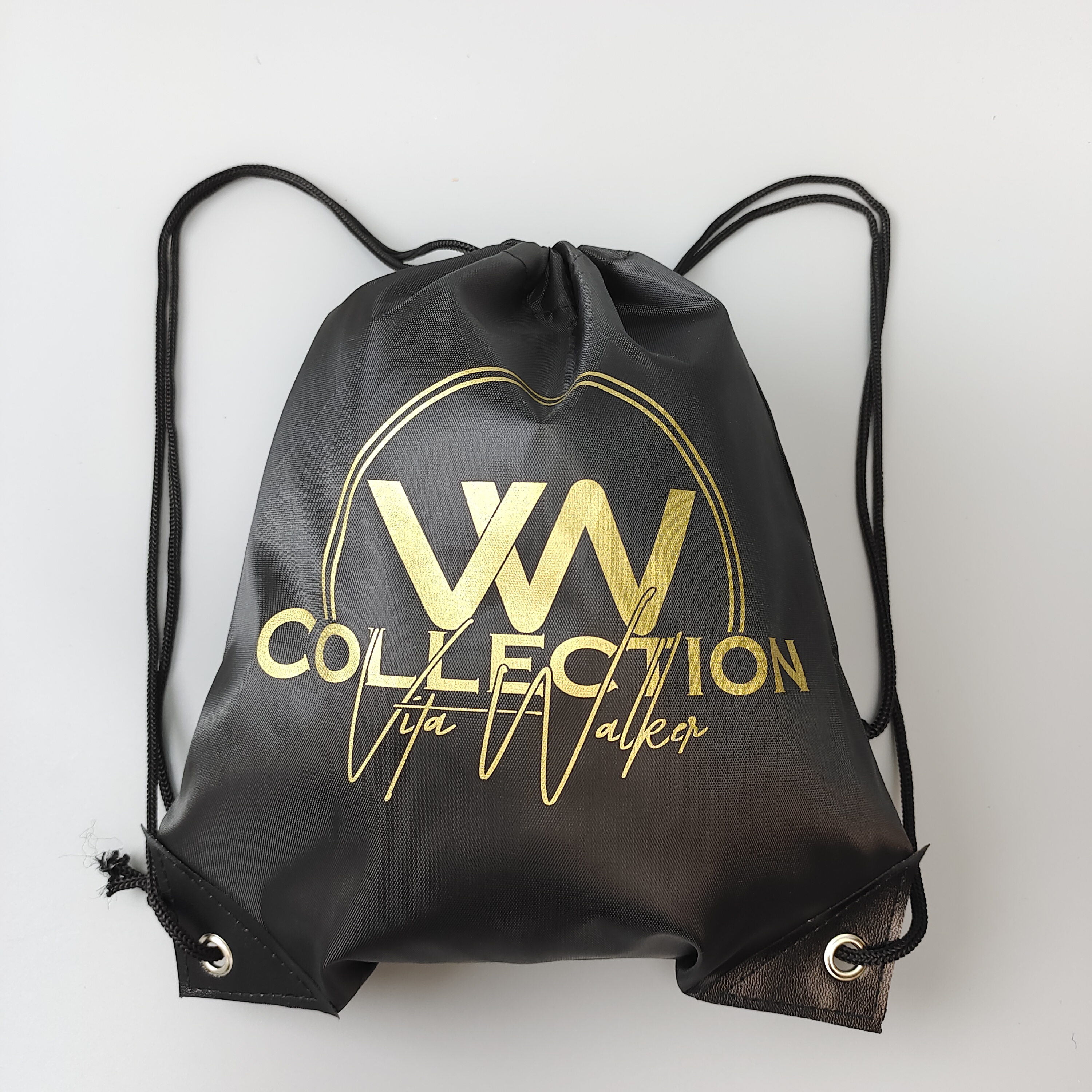 black polyester drawstring backpack with gold-colored logo artwork - view 1