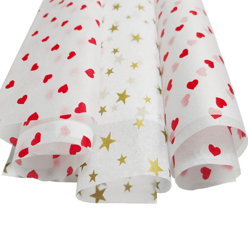 white tissue paper printed with red hearts and gold stars