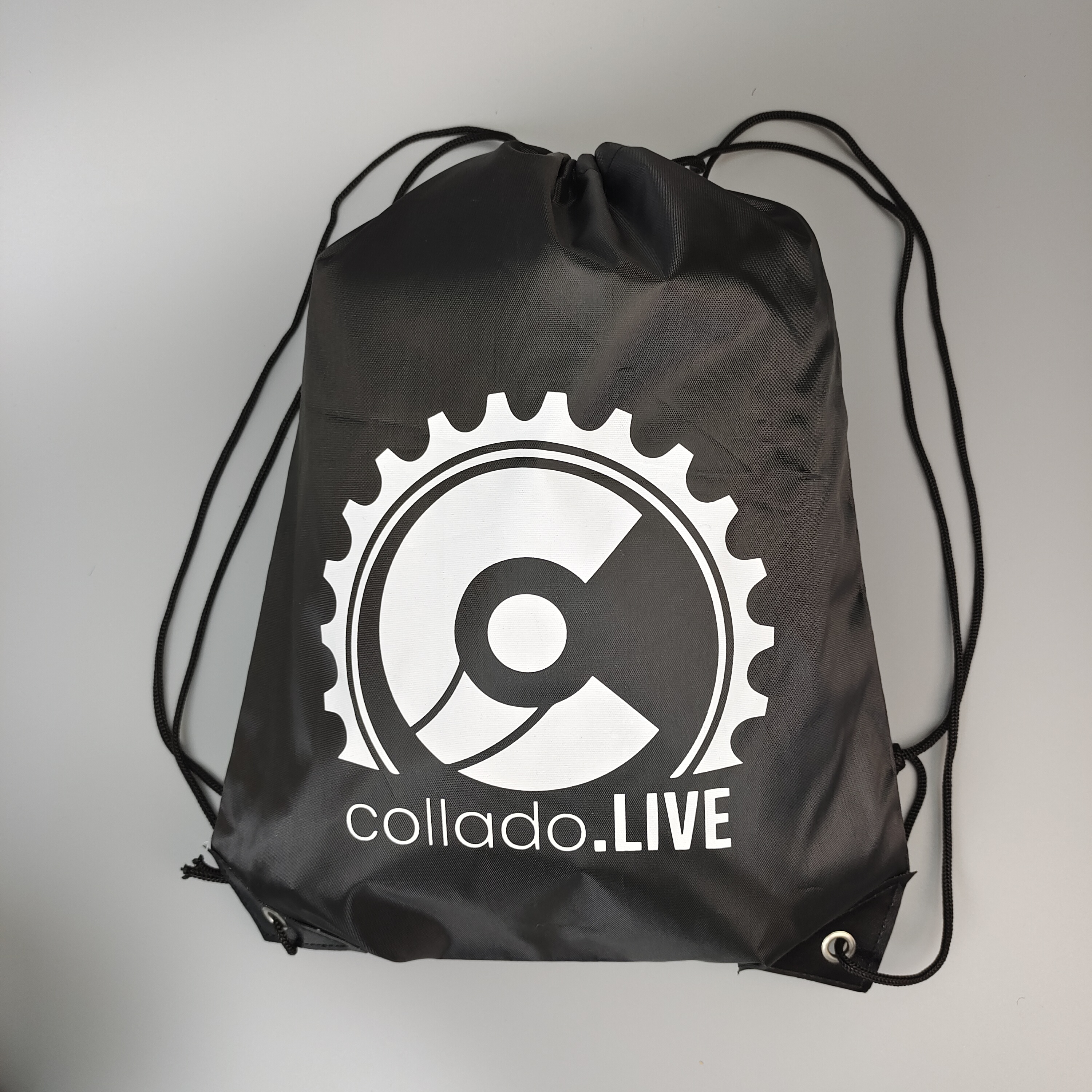 black polyester drawstring backpack with centered white emblem - view 1